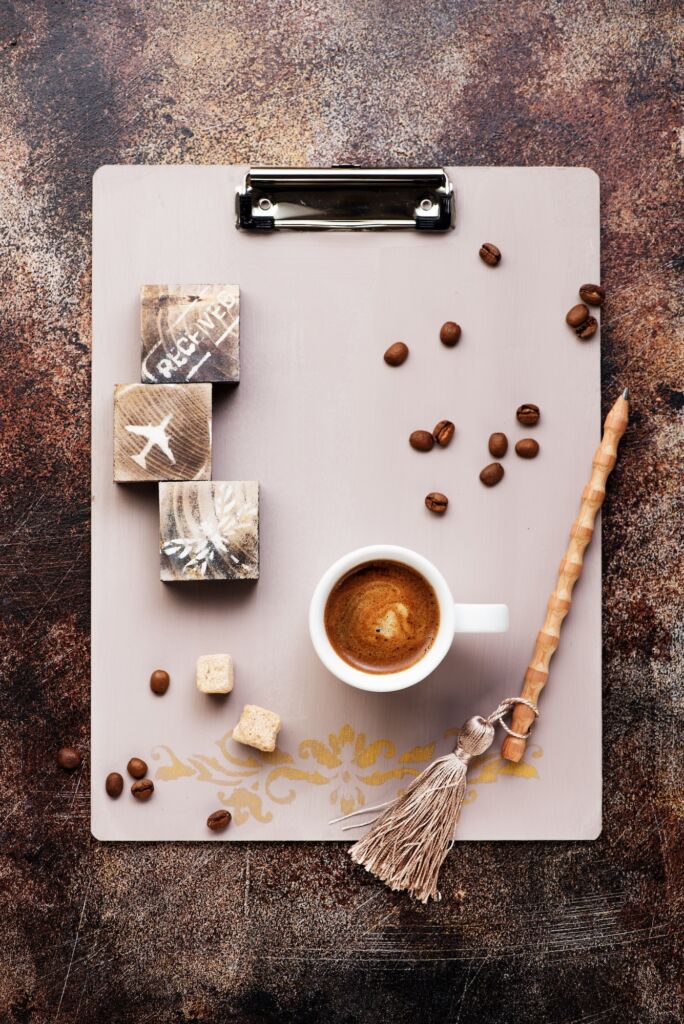 Clipboard, cup coffee, coffee beans and sugar.