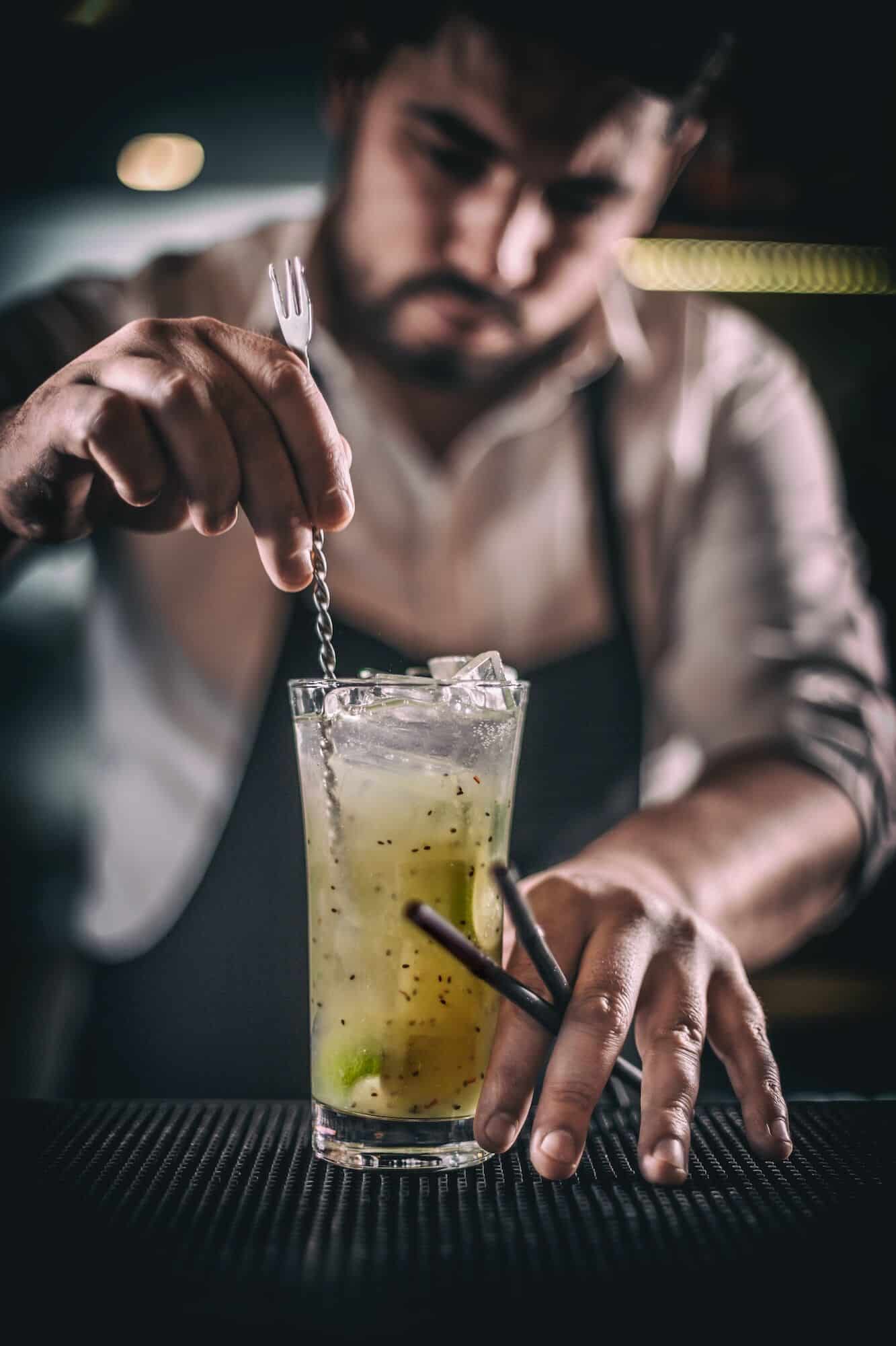 Mixologist stirring a cocktail for a private party in London