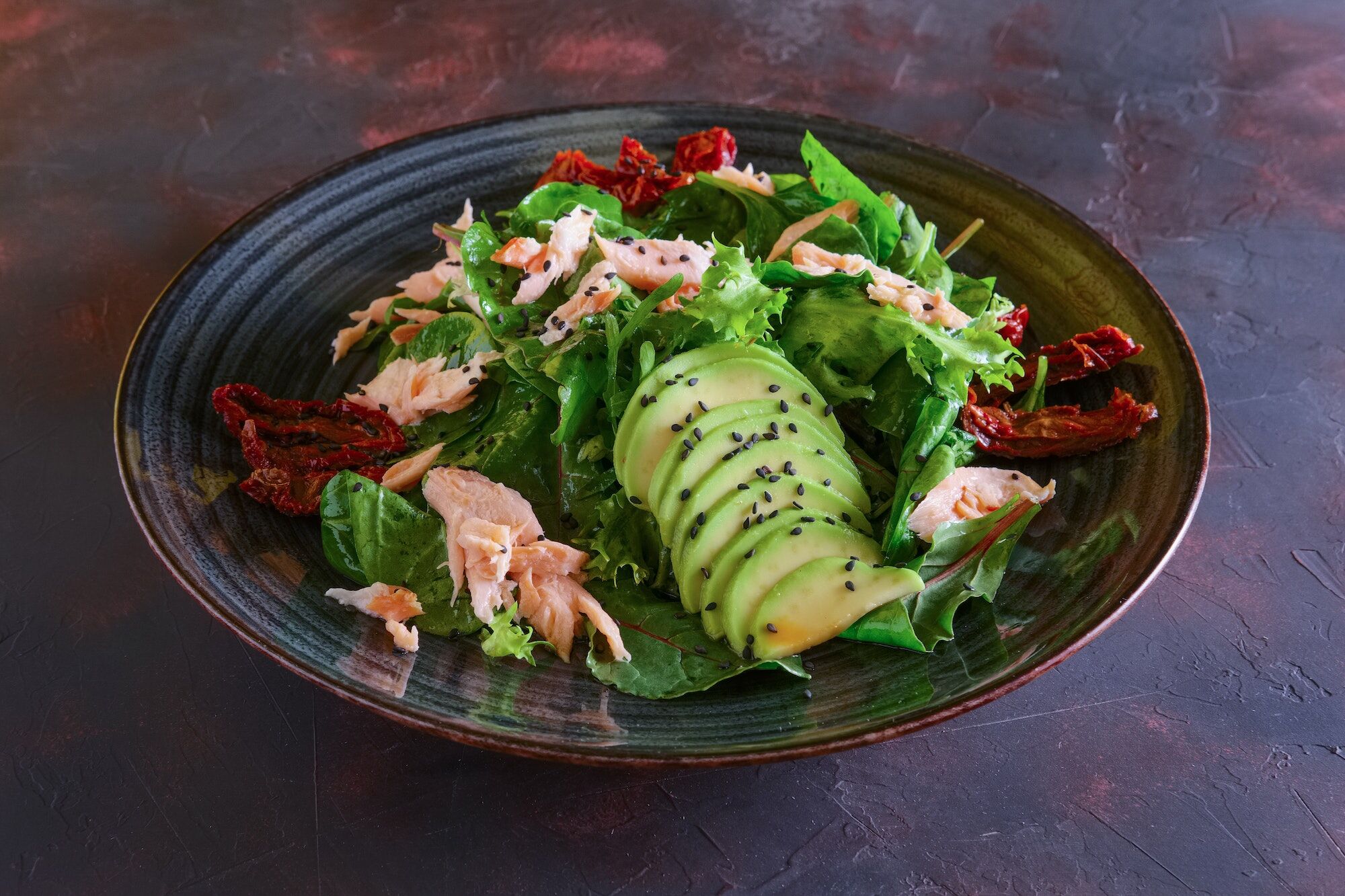 Salad with salmon, avocado and sun dried-tomatoes