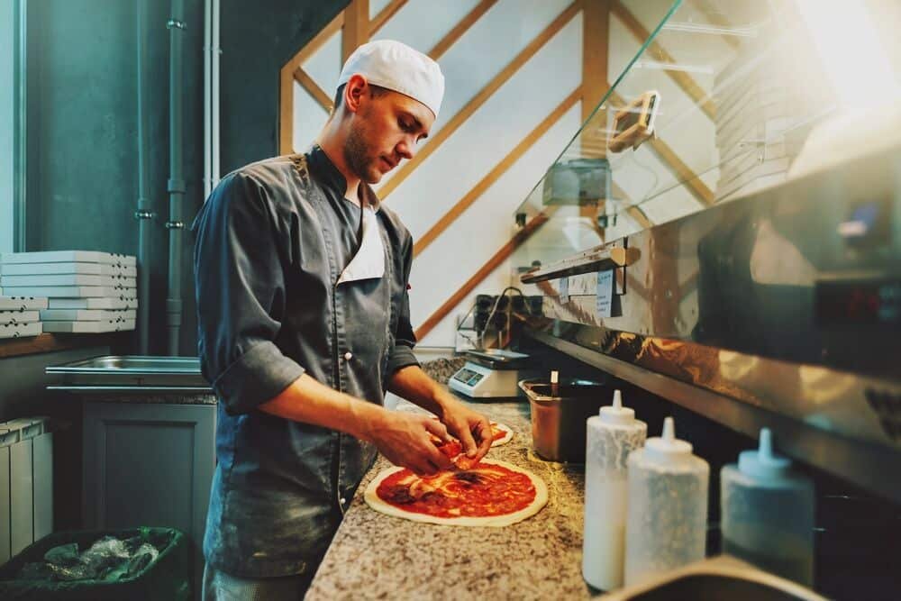 The chef prepares pizza. Catering kitchen work.