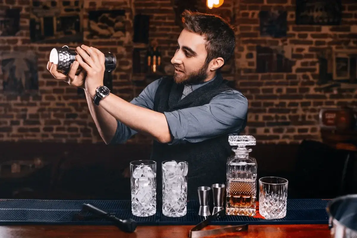 Professional bartender mixing cocktails at Pearl Lemon Catering espresso bar event in Barcelona with premium glassware and spirits