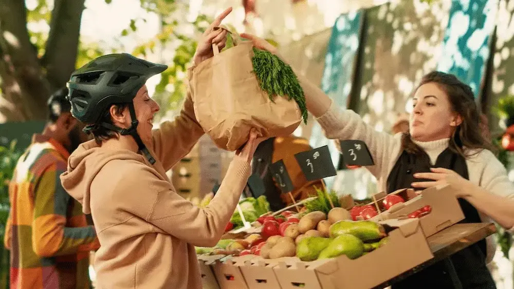 Fresh produce vendors selecting quality fruits and vegetables at farmers market for Pearl Lemon Catering Barcelona ingredients