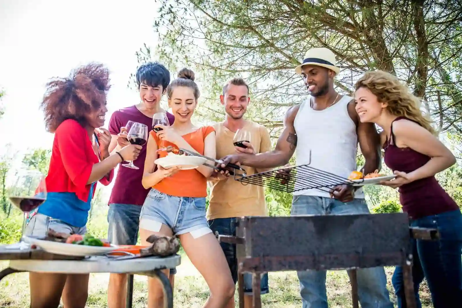 BBQ Event Catering Services in London group of friends enjoying food and drinks at an outdoor barbecue