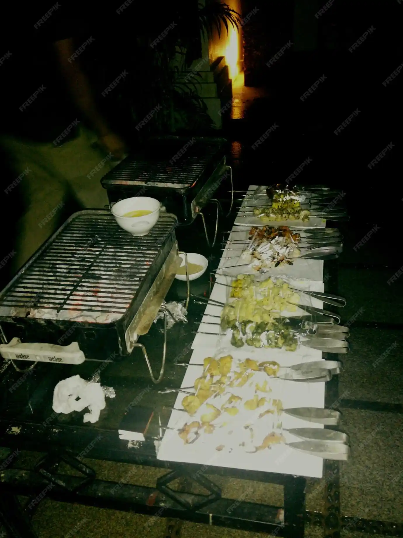 BBQ Event Catering Services in London with assorted skewers and grills at night