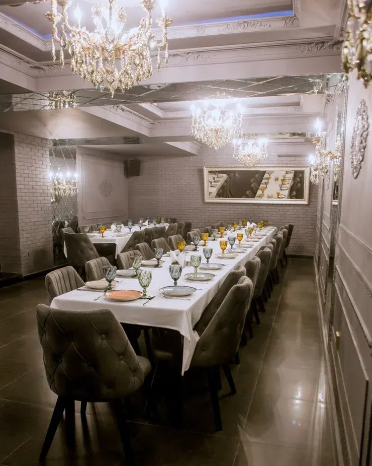 Elegant private dining room setup for Corporate Catering Services in Zurich, Switzerland with crystal chandeliers and formal table setting