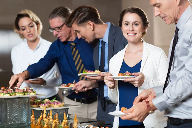 Professional woman selecting gourmet appetizers from elegant catering display at corporate reception