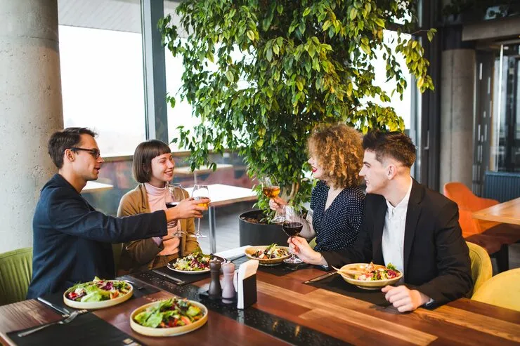 Business professionals toasting with wine during catered client meeting in bright Stockholm office space