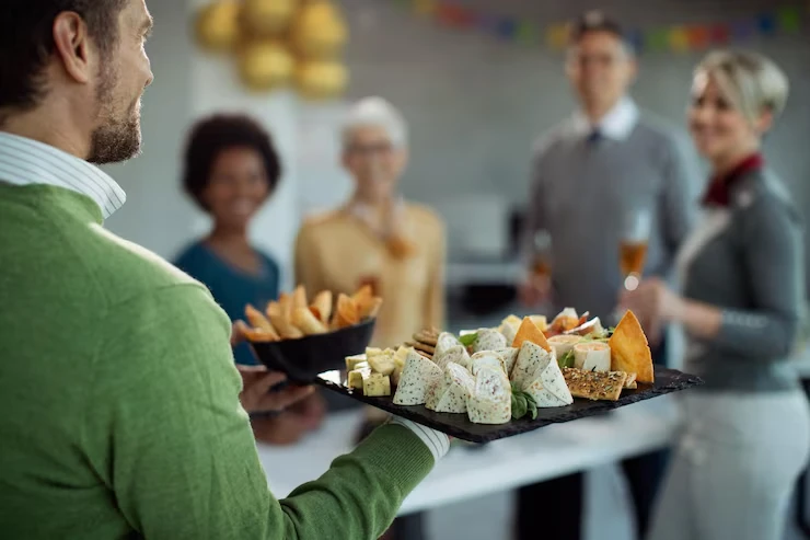 Server carrying elegant canapé platter to business professionals during conference networking break