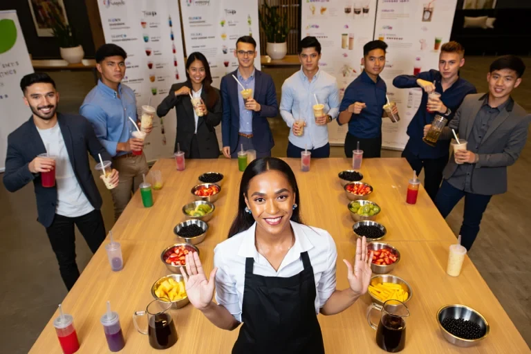 Professional instructor leading bubble tea workshop with participants making drinks using fresh ingredients