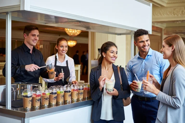 Professional catering staff serving bubble tea drinks to business clients at corporate event
