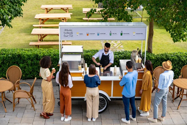 Professional mobile bubble tea cart serving fresh drinks to customers in outdoor park setting