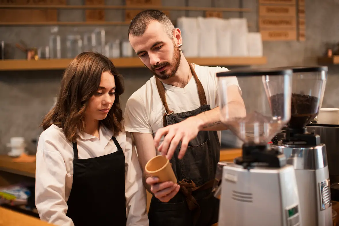 Barista training a team member on preparing coffee, highlighting quality craftsmanship and expertise behind premium coffee catering services in Barcelona.