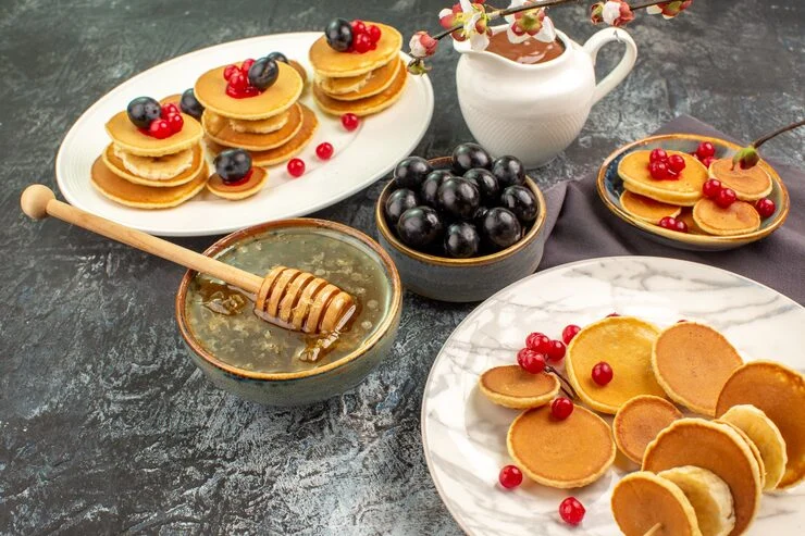 Pancakes with berries, honey, and chocolate spread