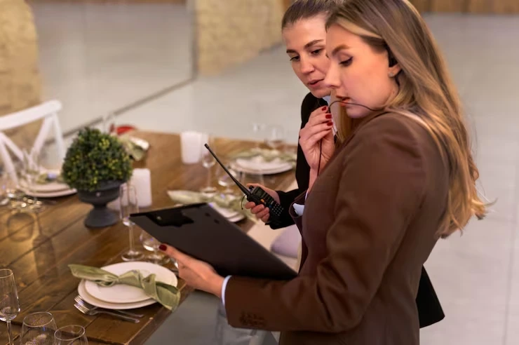 Event planners reviewing table setup with clipboard