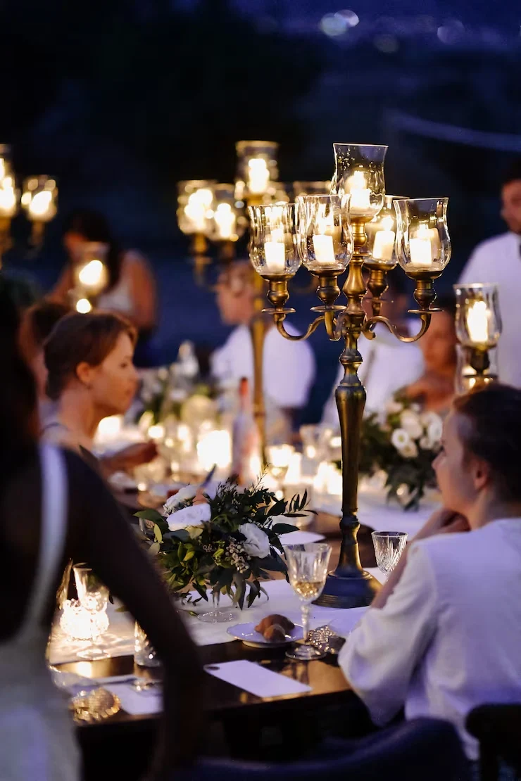 Guests dining at candlelit table with candelabra