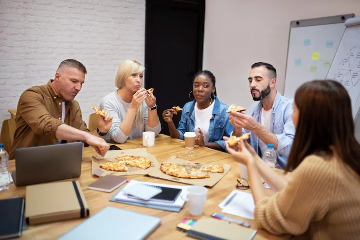 Team enjoying pizza in boardroom