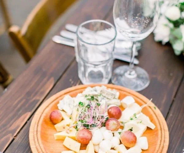 Cutlery and Crockery Hire in London for Your Event featuring a wooden table setting with cheese and grapes
