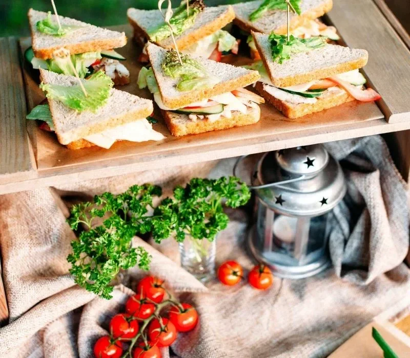 Gourmet coffee catering for events in London featuring artisan sandwiches with microgreens on wooden serving board with fresh ingredients
