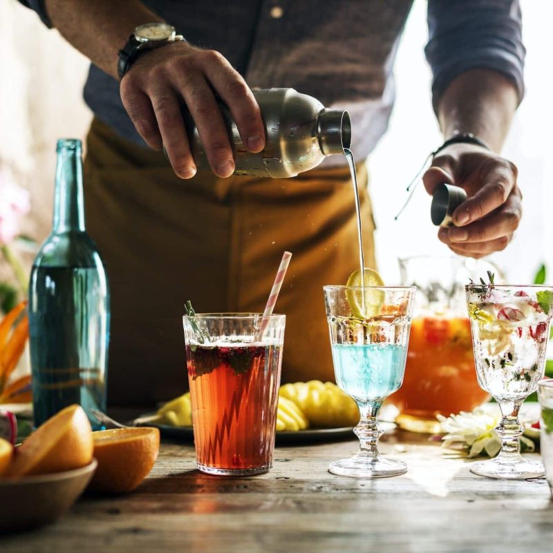 Bartender mixing colorful cocktails