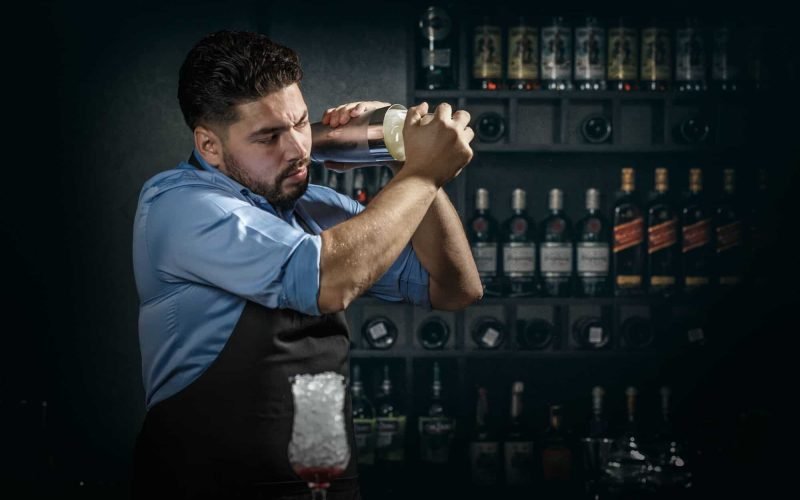 Bartender shakes and mixing