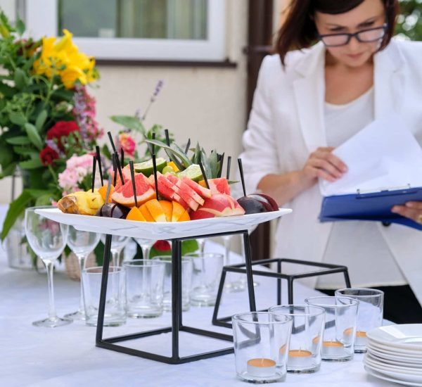 Banquet table with decorative place settings and food arranged for a catered event.