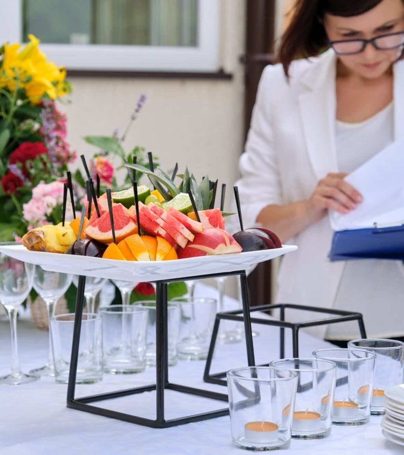 Banquet table with decorative place settings and food arranged for a catered event.