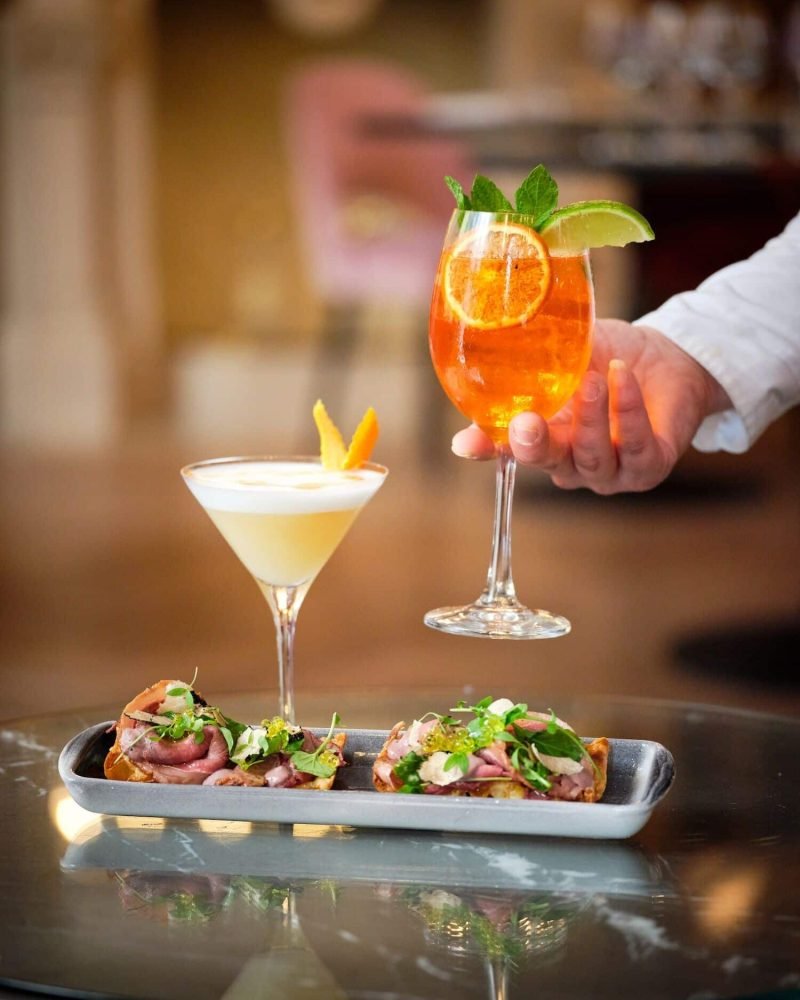 Crop guest taking aperitif cocktail