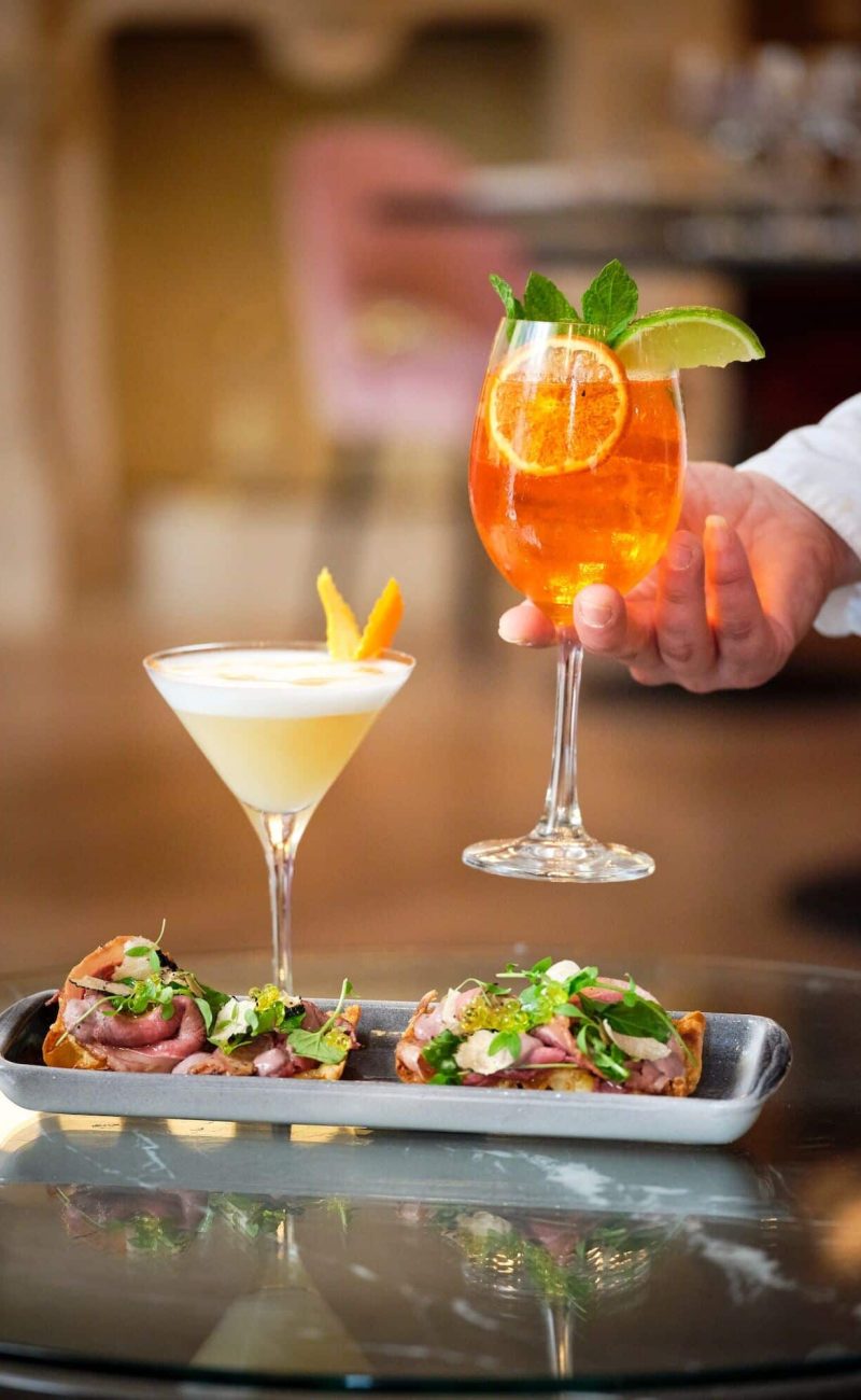 Crop guest taking aperitif cocktail