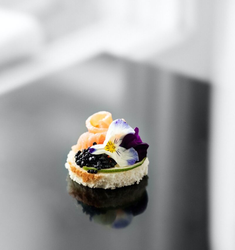 Delicious appetizer with fish and edible flowers. Concept for food, restaurant, menu, catering.