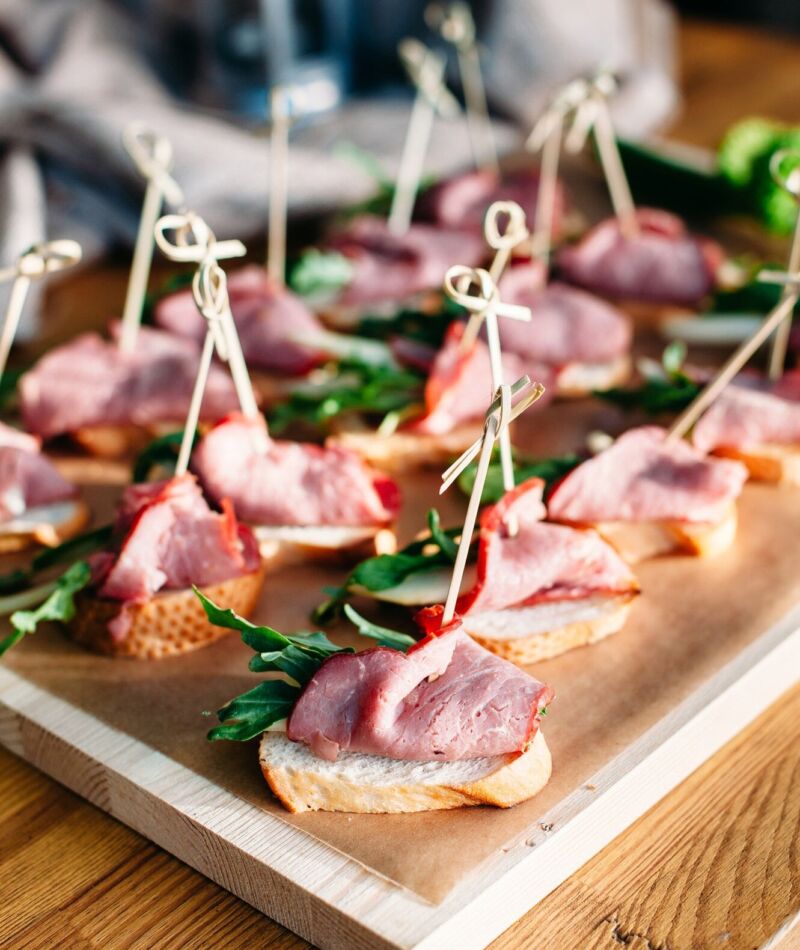Delicious catering banquet buffet table. sandwiches with ham, vegetables and greenery