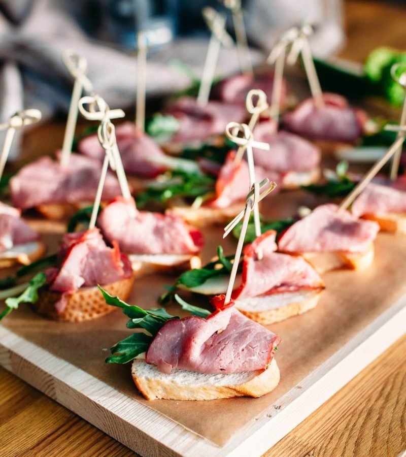 Delicious catering banquet buffet table. sandwiches with ham, vegetables and greenery