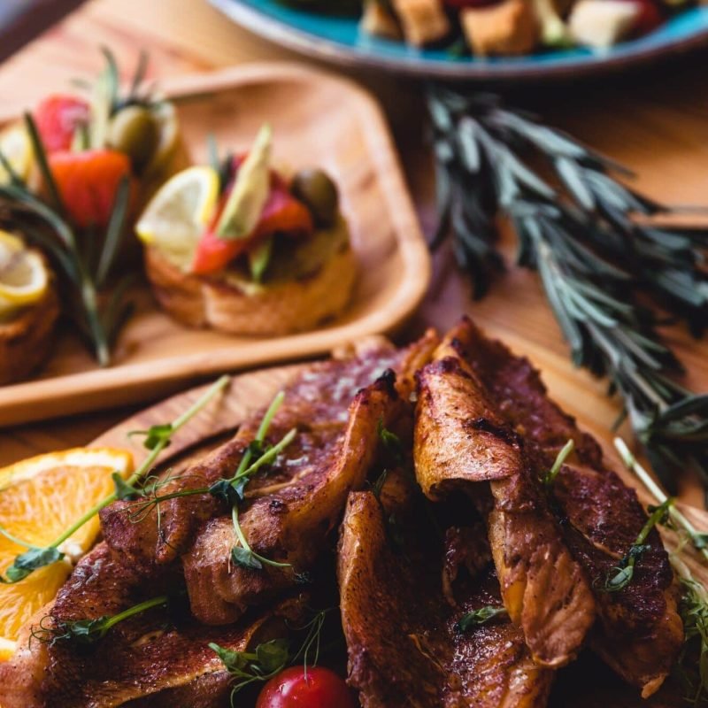 Fish Meat on a Black Tray with Herbs and Spices on Top of a Rustic Wooden Table