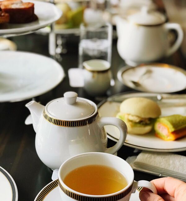 Luxury English afternoon tea party with a cup of tea in hand