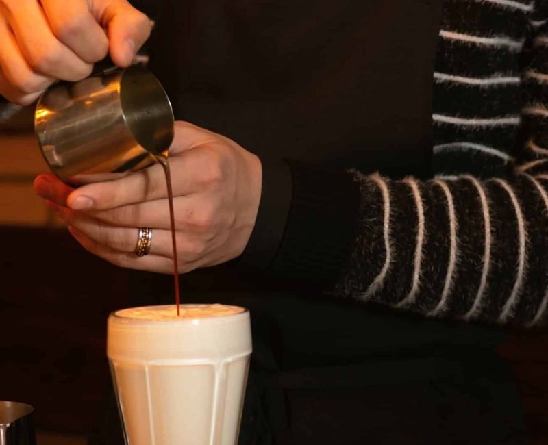 The bartender prepares a drink of coffee for a young girl in a cafe who is waiting for friends, private bartenders for hire in london